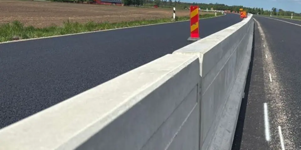 Skyddsbarriär i betong delar ett körfält i två delar på en väg med personbil